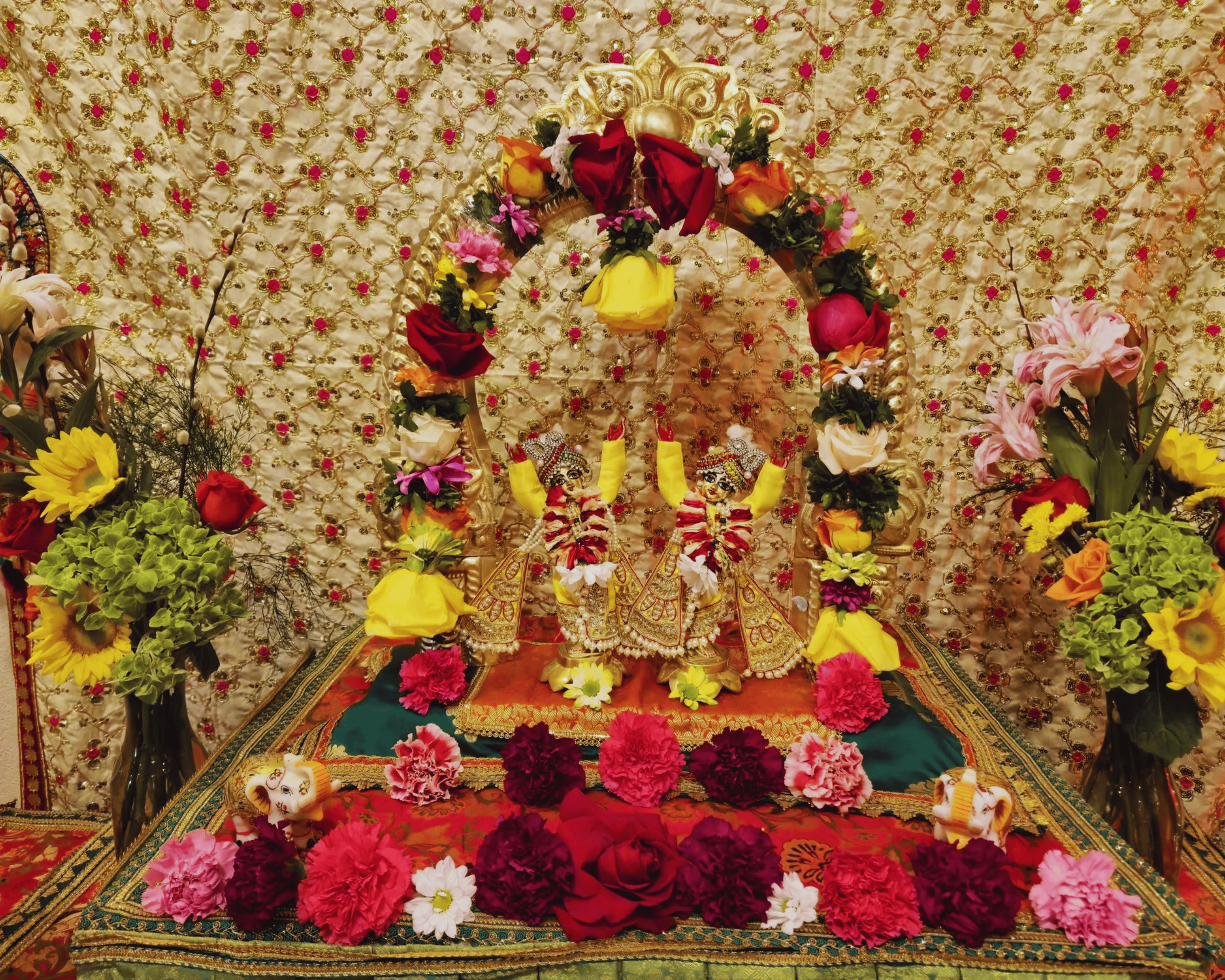 Sacred deity altar with floral offerings at ISKCON Cedar Park