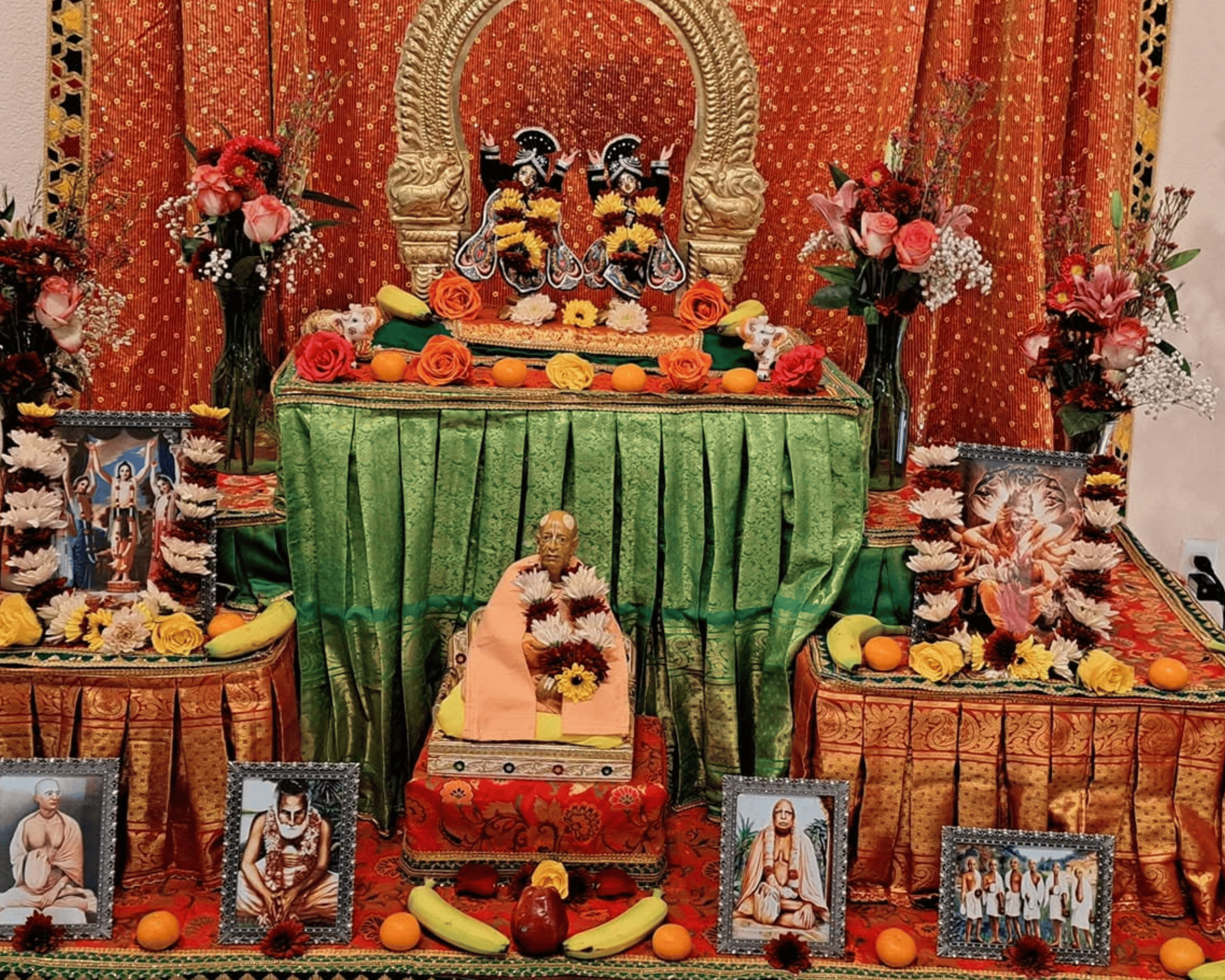 Radha Krishna deities and Srila Prabhupada murti on beautifully decorated altar with flowers and fruits at ISKCON Cedar Park