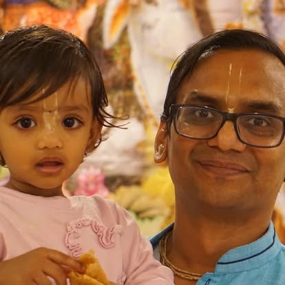 Man holding young child smiling together at ISKCON Cedar Park