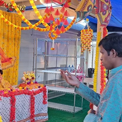 Man decorating Diwali festival entrance colorfully at ISKCON Cedar Park