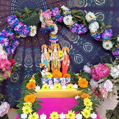 Hindu deity altar surrounded by colorful flowers at ISKCON Cedar Park