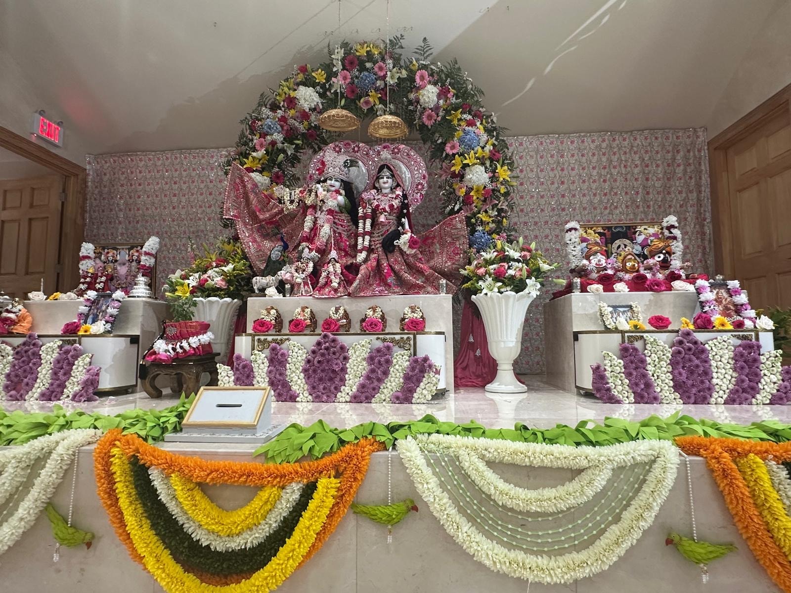 Sri Sri Radha Krishna altar beautifully adorned with flowers during the temple inauguration